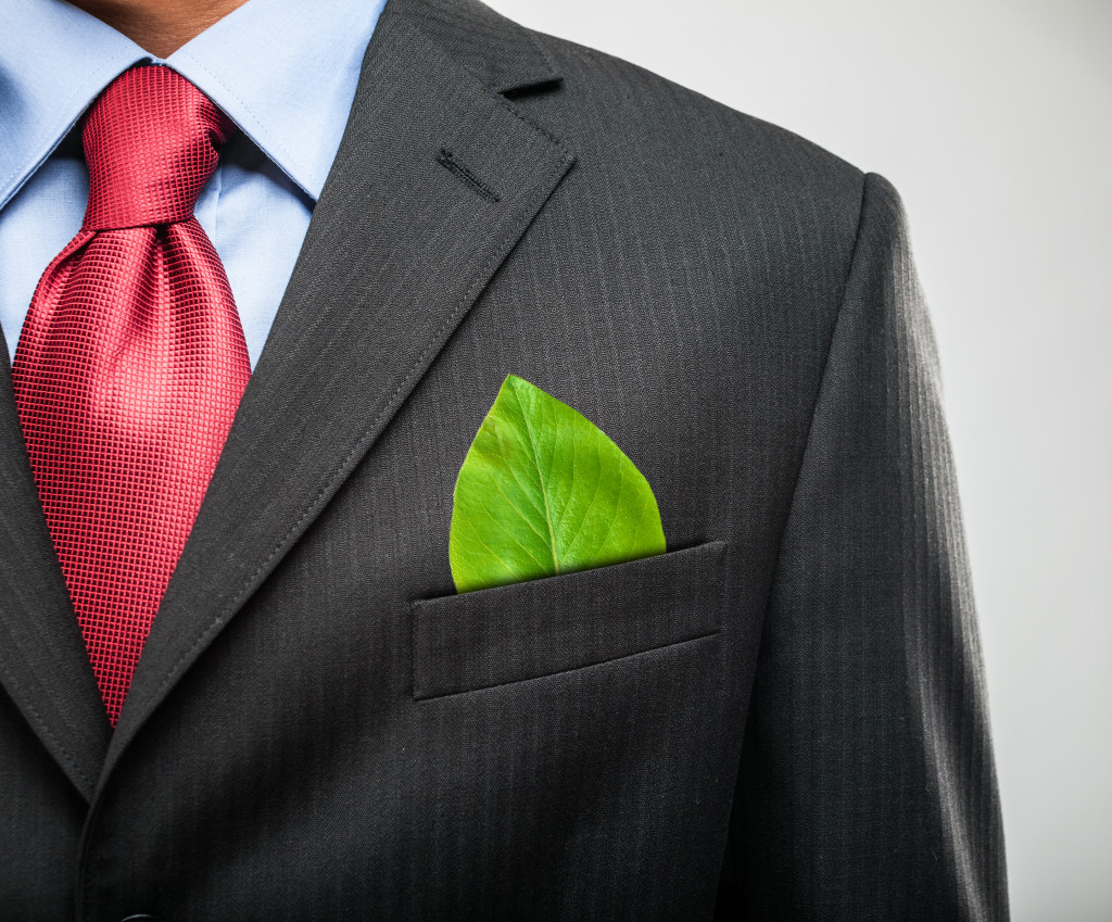 Man with a green leaf on the breast pocket of his suit. 